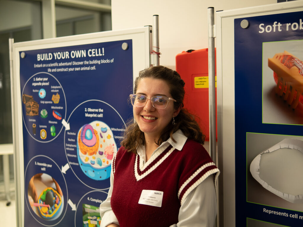 A research is smiling at the PULS booth.